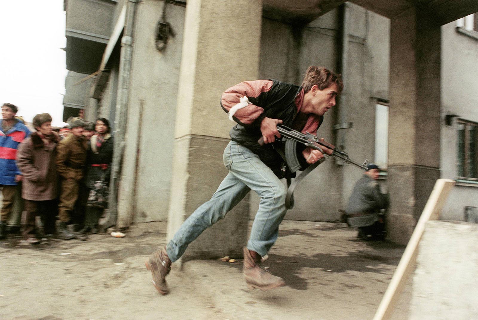 An anti-Communist civilian fighter armed with a Kalashnikov AK-47 chases the supposedly Securitate secret police agents loyal to the communist power during a street-fighting.