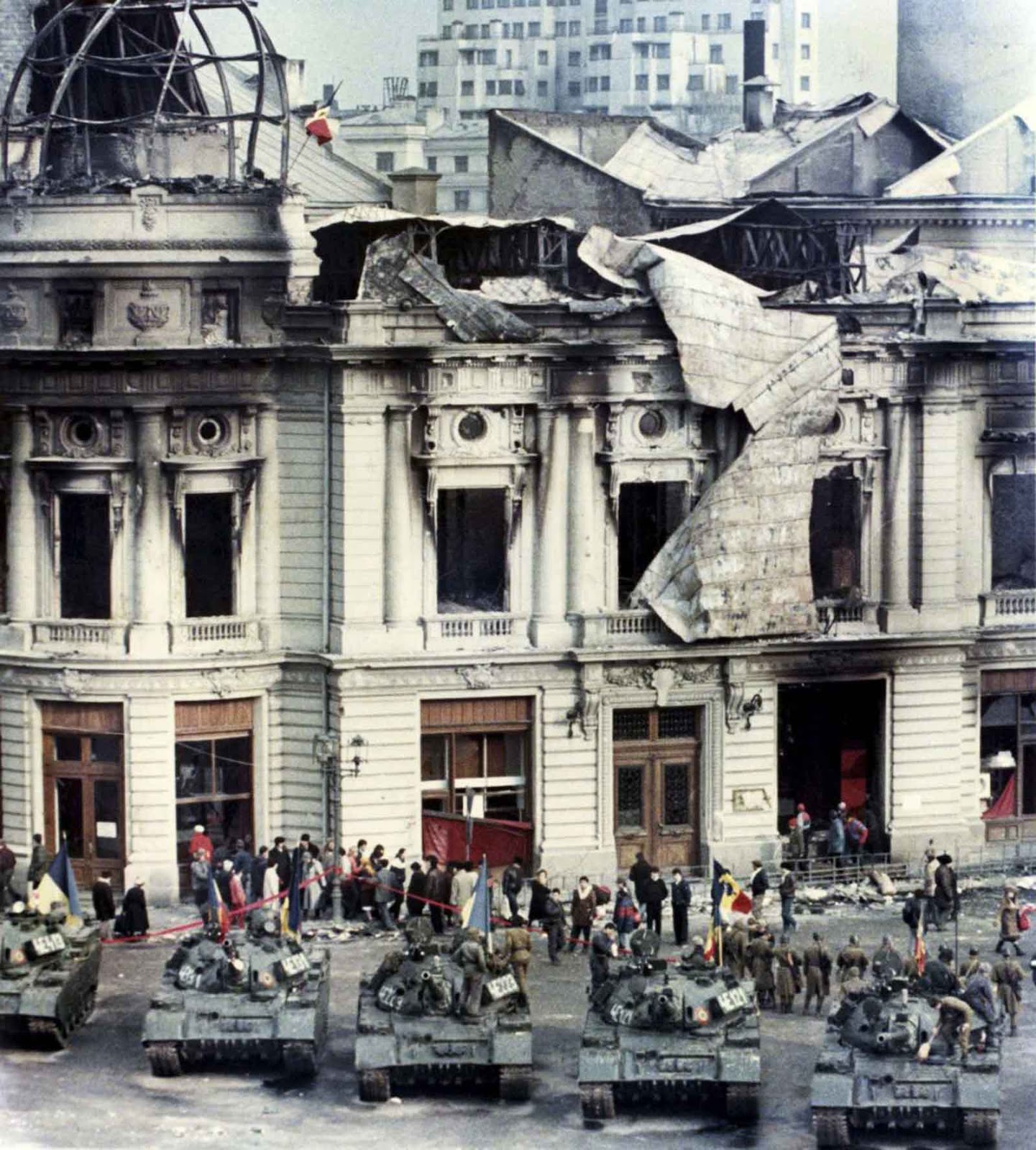 Civilians standing behind tanks after a battle between the army backed up by armed civilians and pro-Ceausescu supporters in Bucharest.