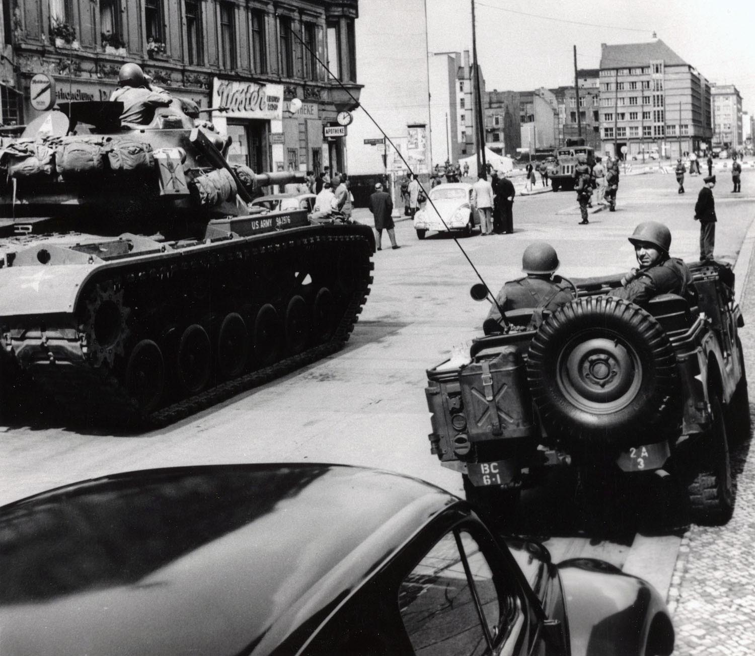 American tanks face an East German water cannon at Checkpoint Charlie.