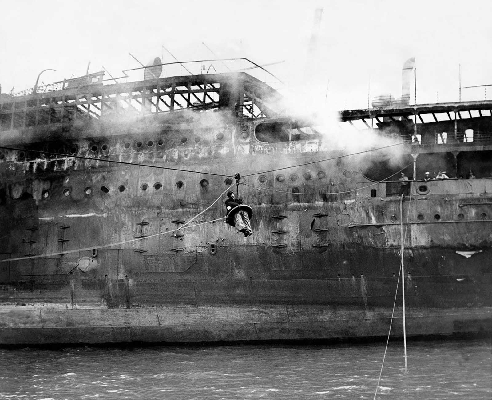 New York Daily News photographer Larry Froeber is brought back to shore after collapsing and burning his hands while shooting the fire.