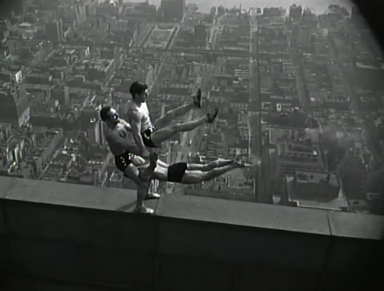 Acrobats balance on top of the Empire State Building