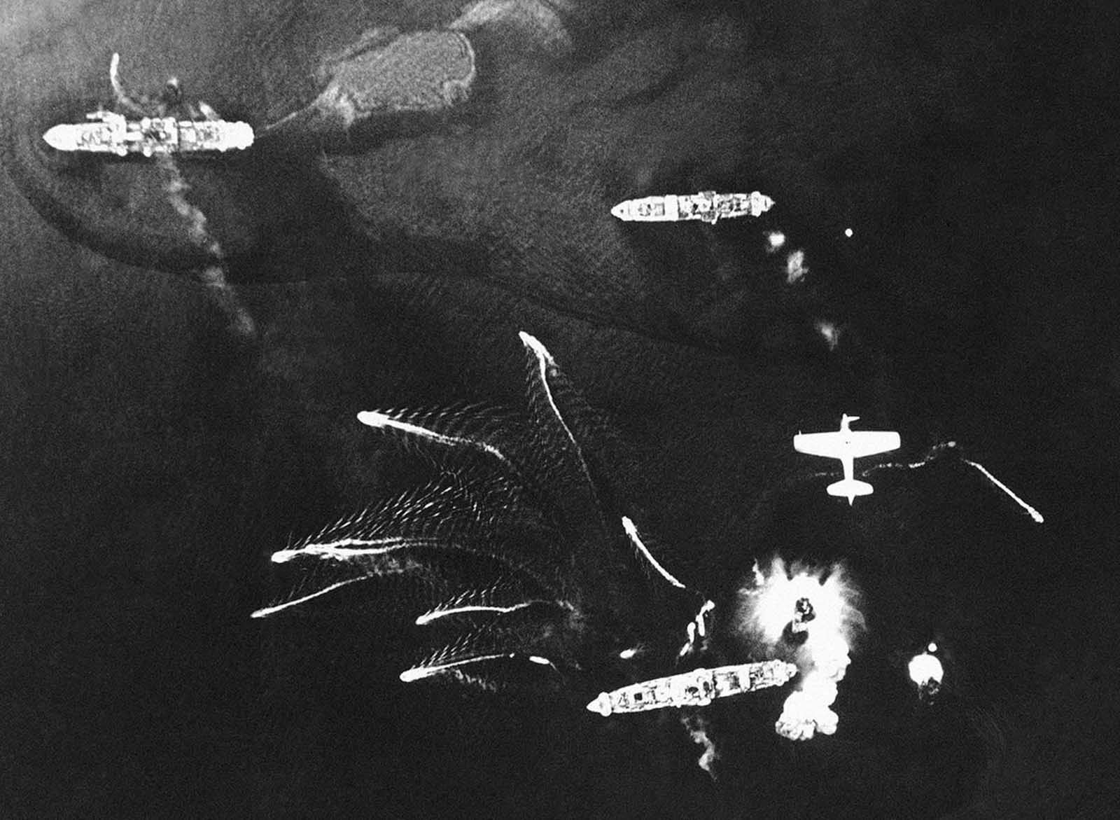 Small Japanese craft flee from larger vessels during an American aerial attack on Tonolei Harbor, Japanese base on Bougainville Island, in the Central Solomon Islands on October 9, 1943.