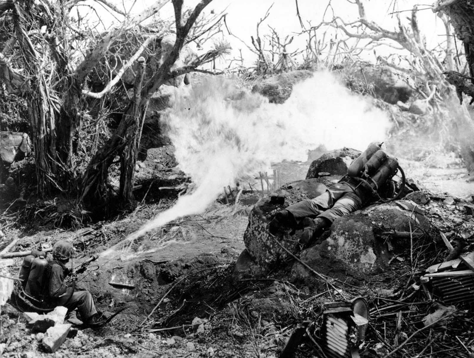 Two U.S. Marines direct flame throwers at Japanese defenses that block the way to Iwo Jima's Mount Suribachi on March 4, 1945. On the left is Pvt. Richard Klatt, of North Fond Dulac, Wisconsin, and on the right is PFC Wilfred Voegeli.