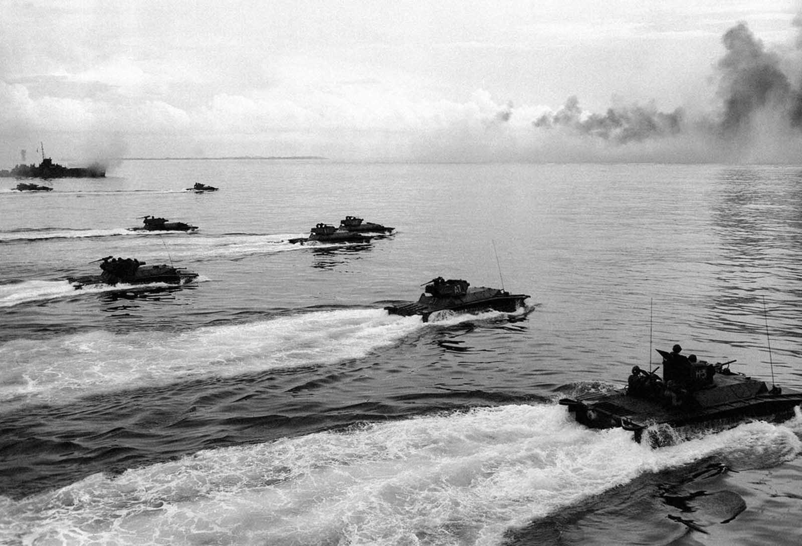 As a rocket-firing LCI lays down a barrage on the already obscured beach on Peleliu, a wave of Alligators (LVTs, or Landing Vehicle Tracked) churn toward the defenses of the strategic island September 15, 1944. The amphibious tanks with turret-housed cannons went in in after heavy air and sea bombardment. Army and Marine assault units stormed ashore on Peleliu on September 15, and it was announced that organized resistance was almost entirely ended on September 27.