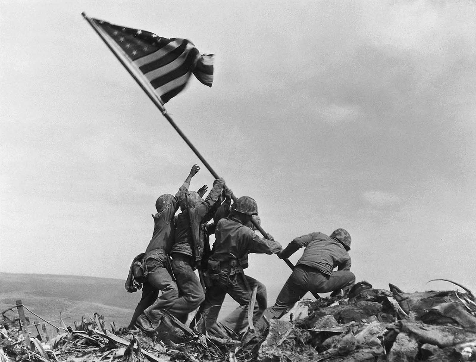 U.S. Marines of the 28th Regiment of the Fifth Division raise the American flag atop Mt. Suribachi, Iwo Jima, on February 23, 1945. The Battle of Iwo Jima was the costliest in Marine Corps history, with almost 7,000 Americans killed in 36 days of fighting.