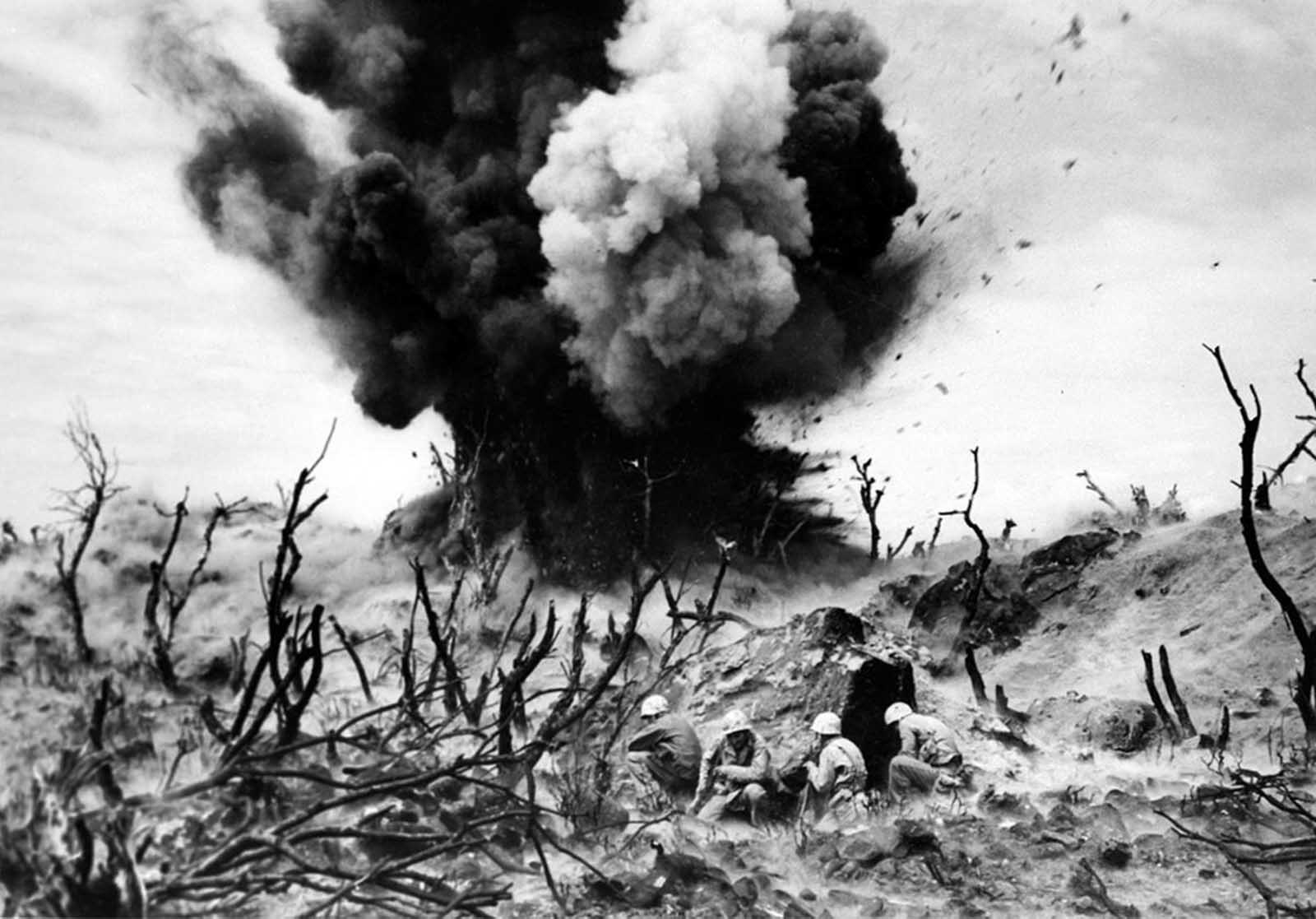 An attack on one of the caves connected to a three-tier blockhouse destroys the structure on the edge of Turkey Nob, giving a clear view of the beachhead toward the southwest on Iwo Jima, as U.S. Marines storm the island on April 2, 1945.