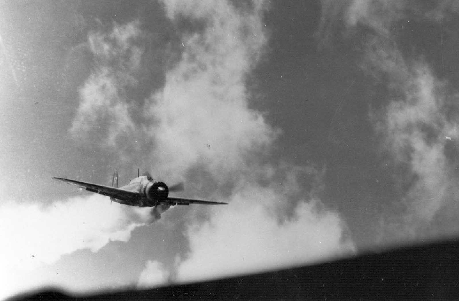A closer view of the Japanese kamikaze aircraft, smoking from antiaircraft hits and veering slightly to left moments before slamming into the USS Essex on November 25, 1944.