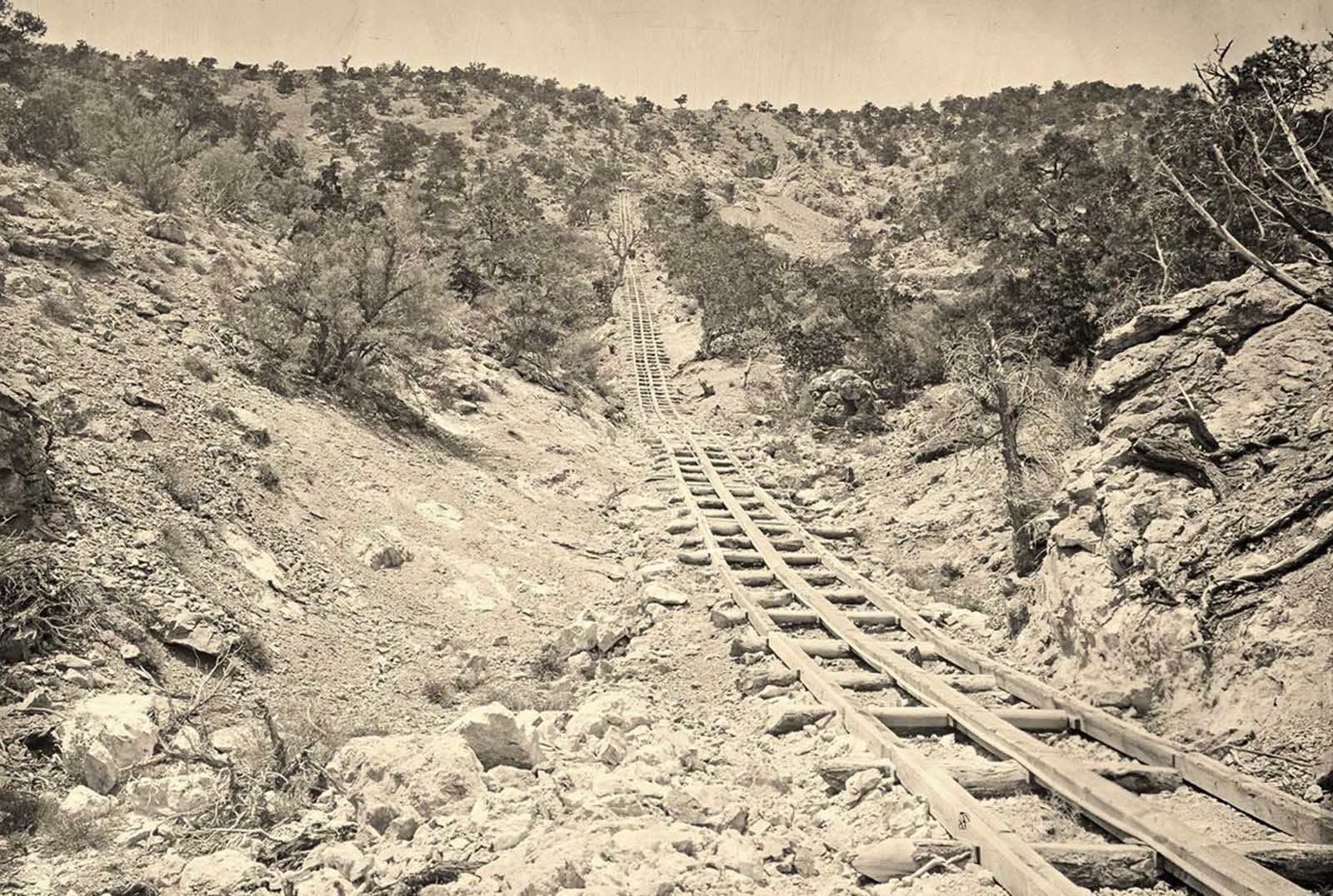 A wooden balanced incline used for gold mining, at the Illinois Mine in the Pahranagat Mining District, Nevada in 1871. An ore car would ride on parallel tracks connected to a pulley wheel at the top of tracks.