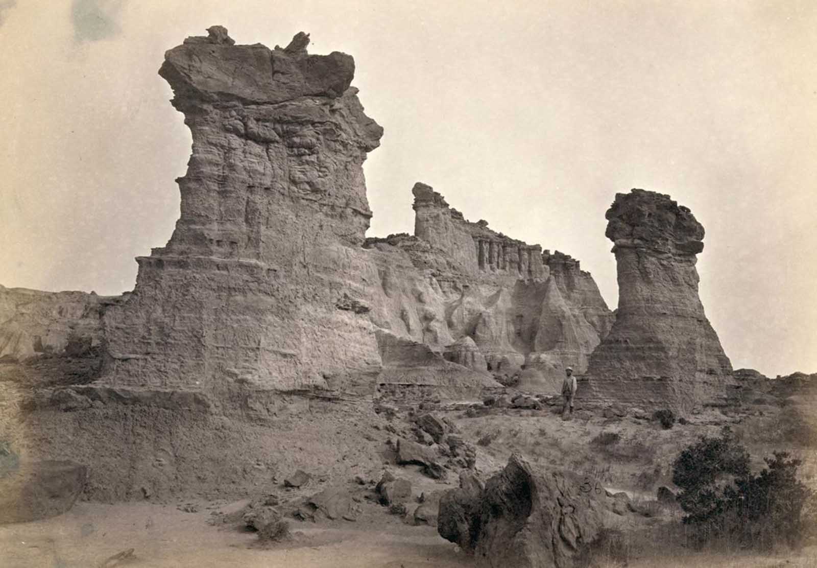 Rock formations in the Washakie Badlands, Wyoming, in 1872. A survey member stands at lower right for scale.