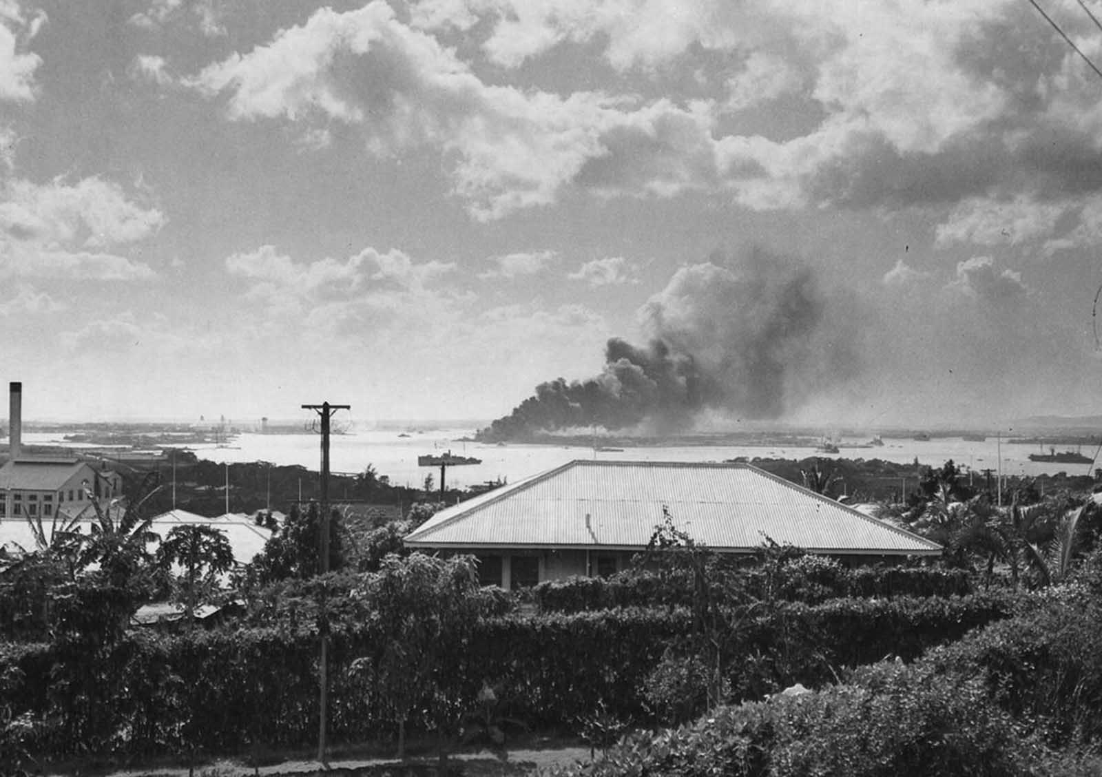Seen from a distance, the Battleship Arizona burns as it sinks in Pearl Harbor after the December 7, 1941 raid by Japanese bombers.