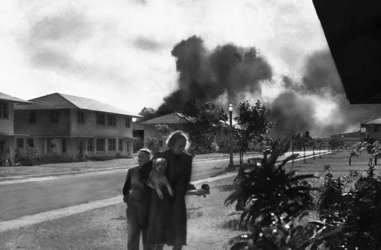 Officers' wives, investigating explosions and seeing a smoke pall in distance on December 7, 1941, heard neighbor Mary Naiden, then an Army hostess who took this picture, exclaim