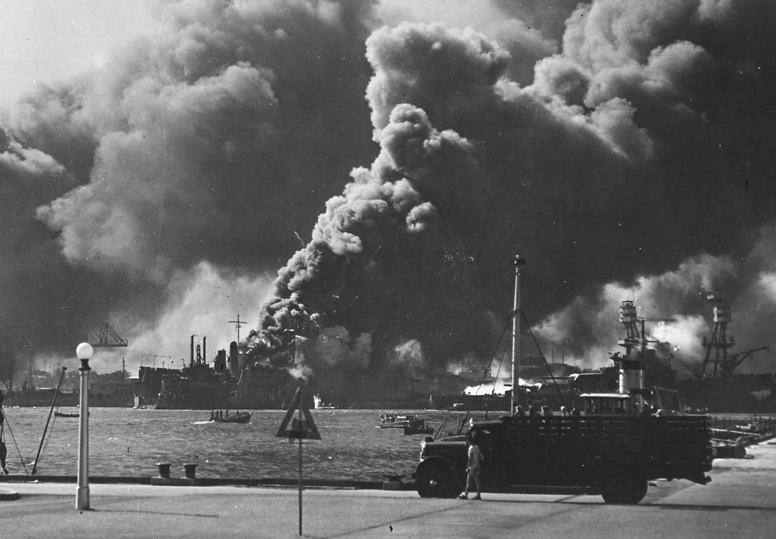 The USS Shaw burns in Pearl Harbor. Japanese bombers hit the forward portion of the ship with three bombs. The resulting fires proved uncontrollable, and Shaw was ordered abandoned. Soon after, her forward ammunition magazines detonated in a spectacular blast, completely removing her bow.