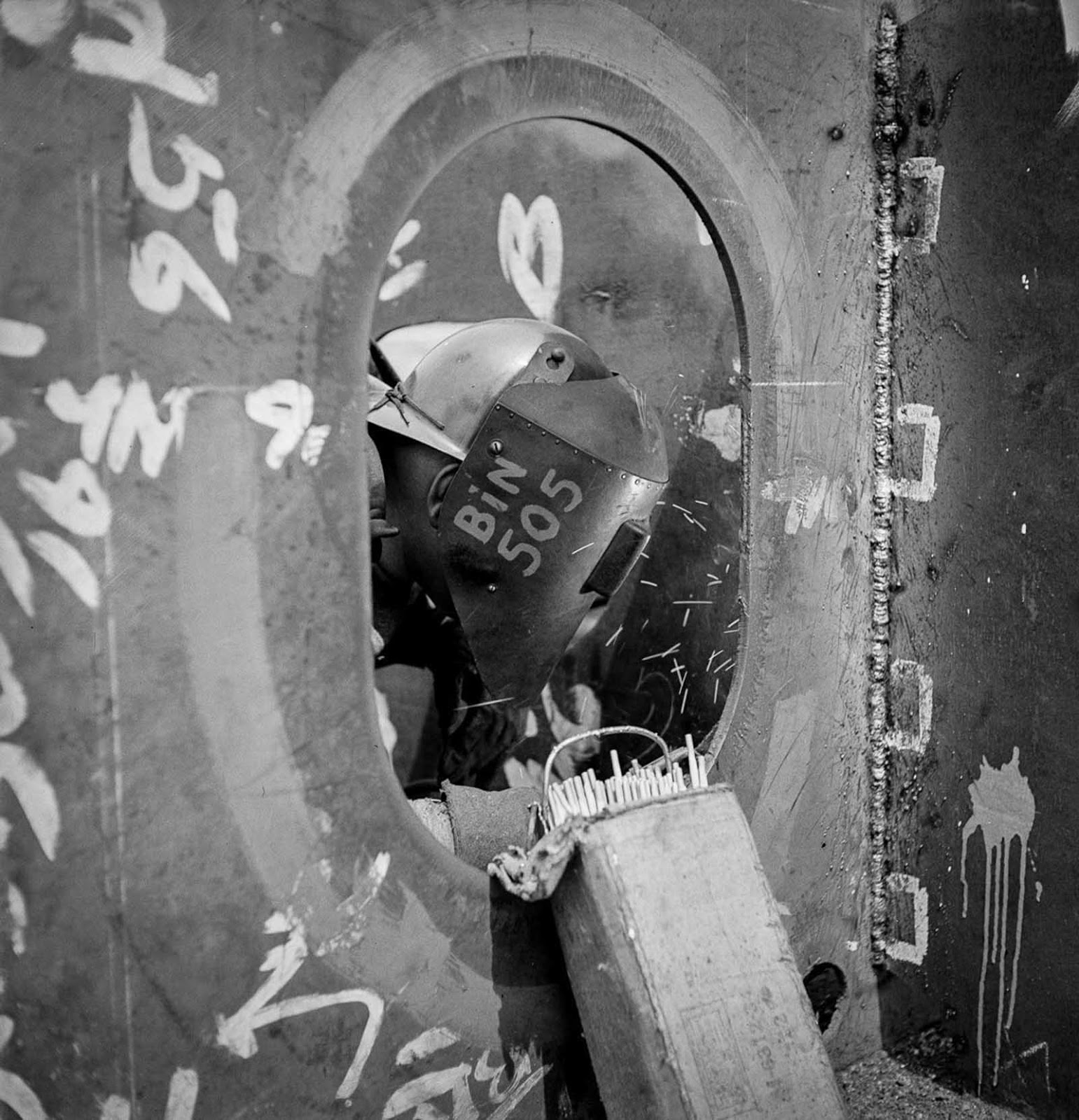 A worker welds a floor to a vertical keel.