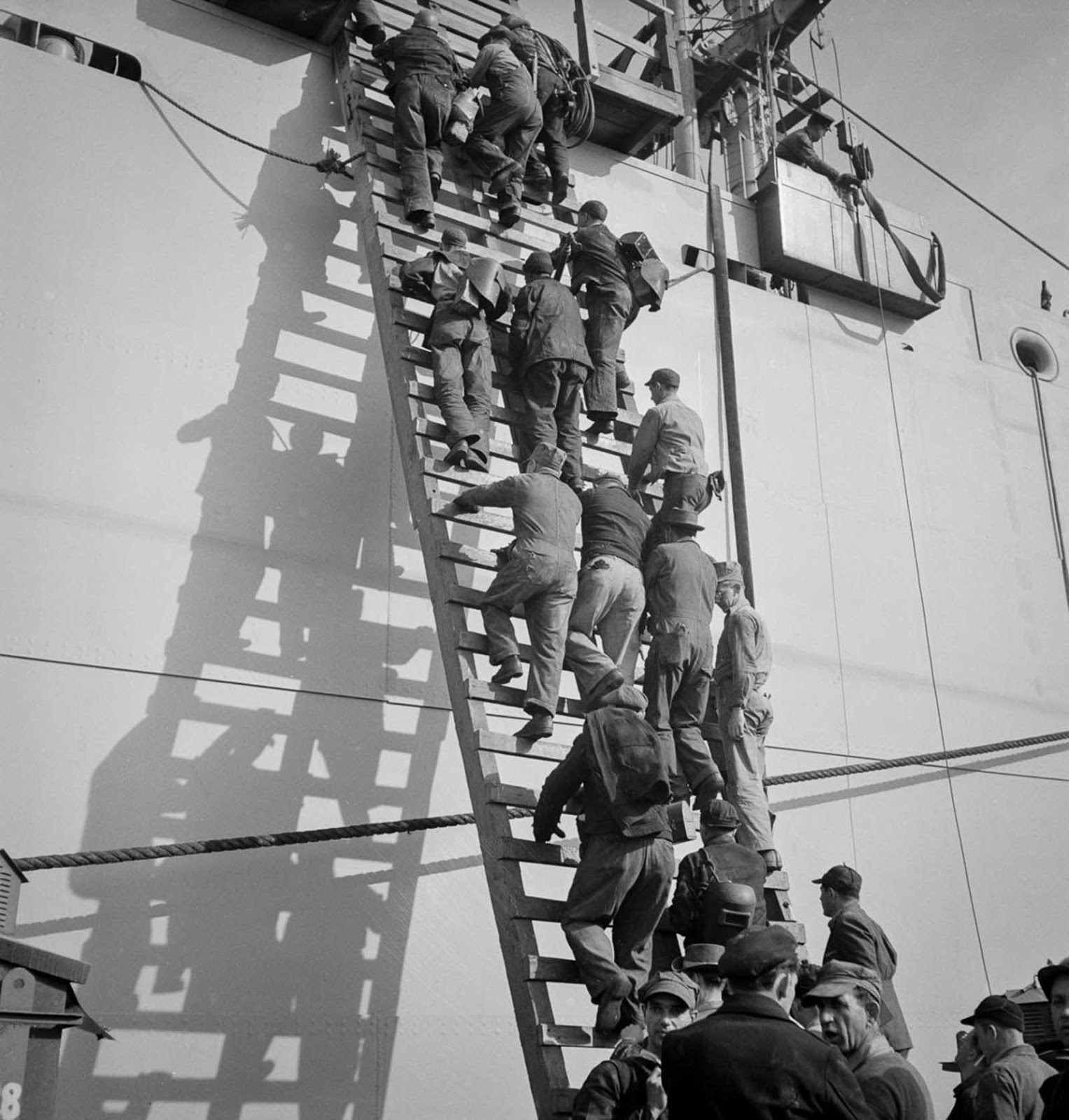 Workers climb a ladder on the outfitting pier.