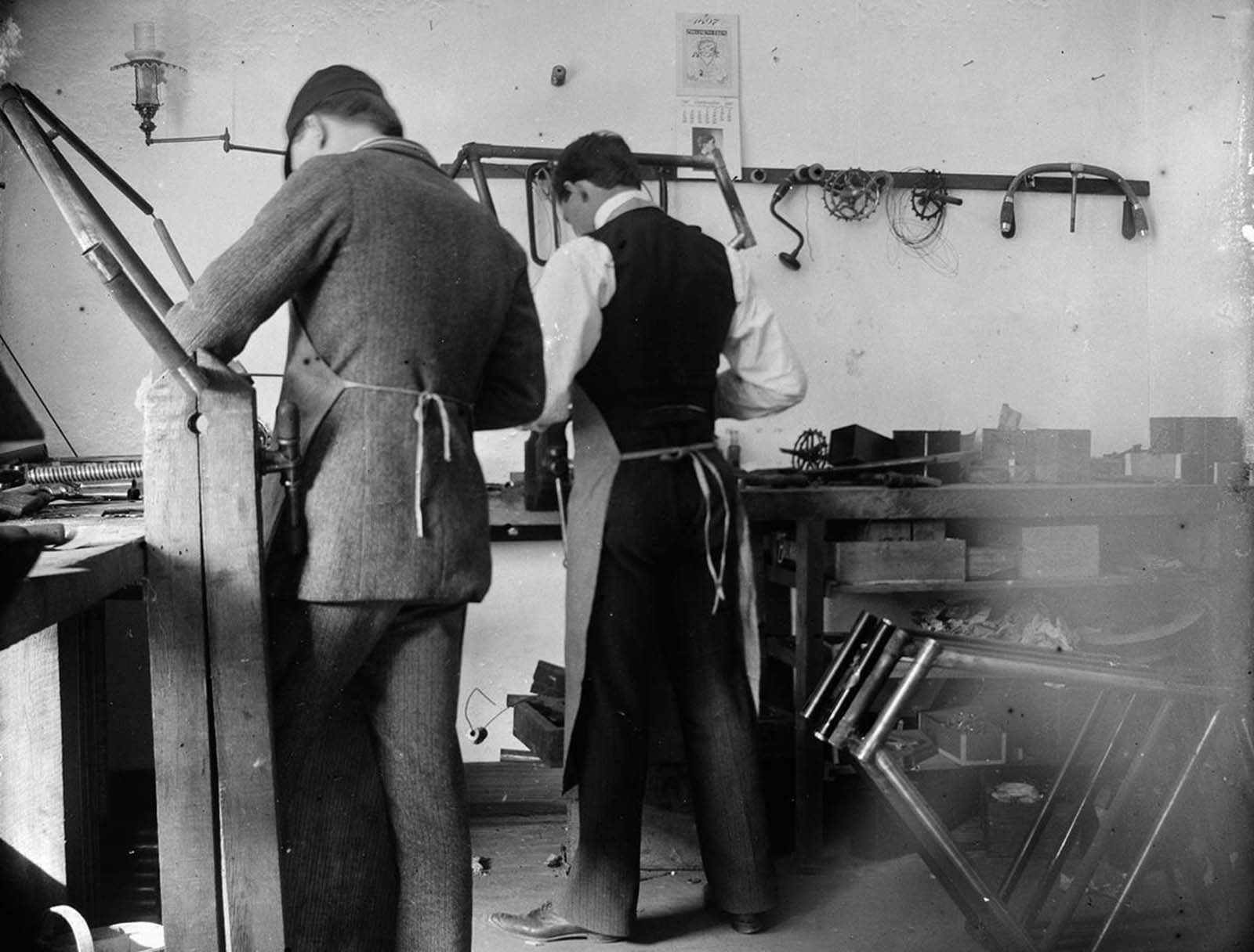 Orville Wright and Edwin H. Sines, neighbor and boyhood friend, filing frames in the back of the Wright bicycle shop in 1897.