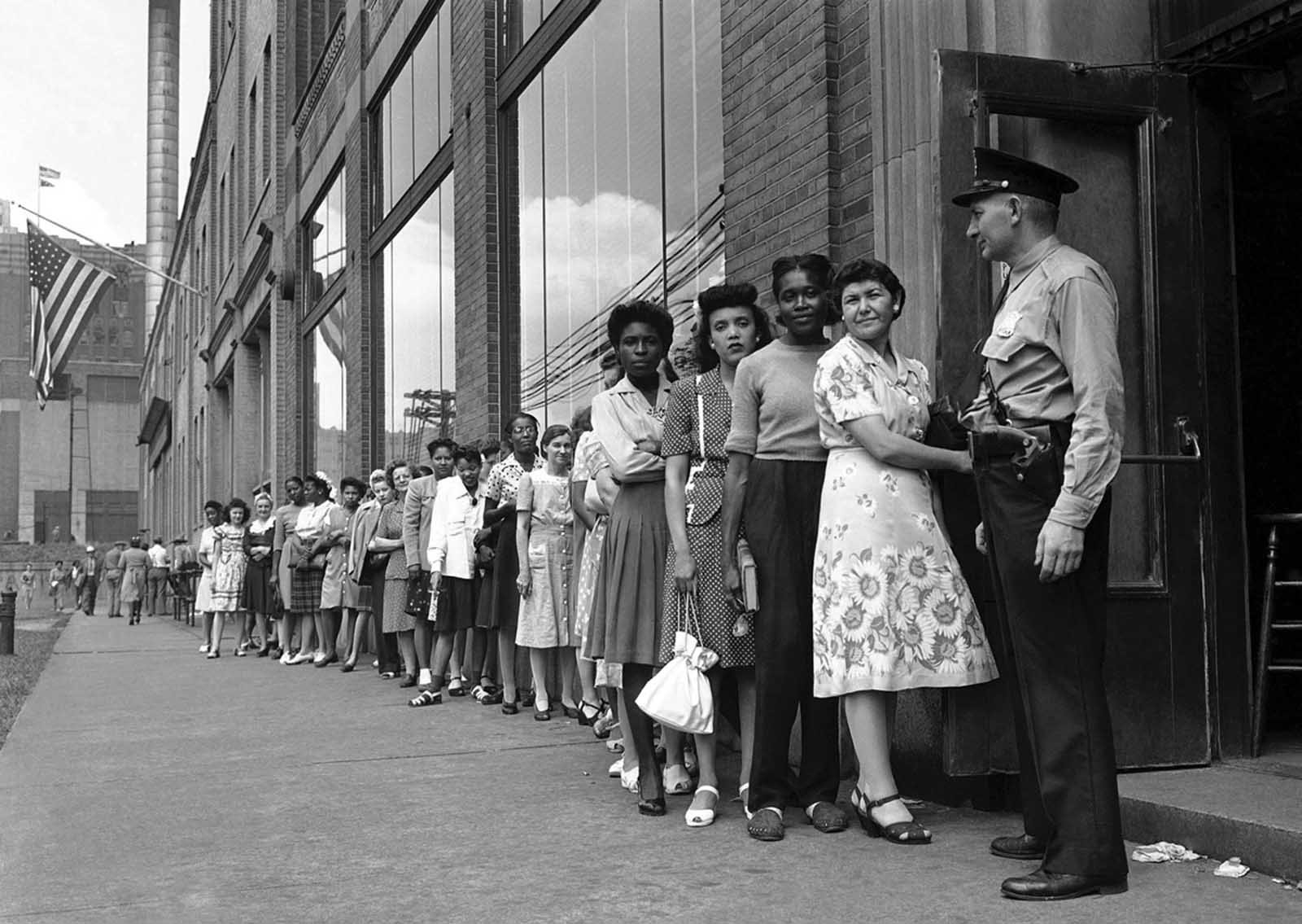 Men and women, formerly employed in defense work, crowd Detroit branch of War Manpower Commission to file claims for unemployment benefits and also register for new jobs on August 17, 1945.
