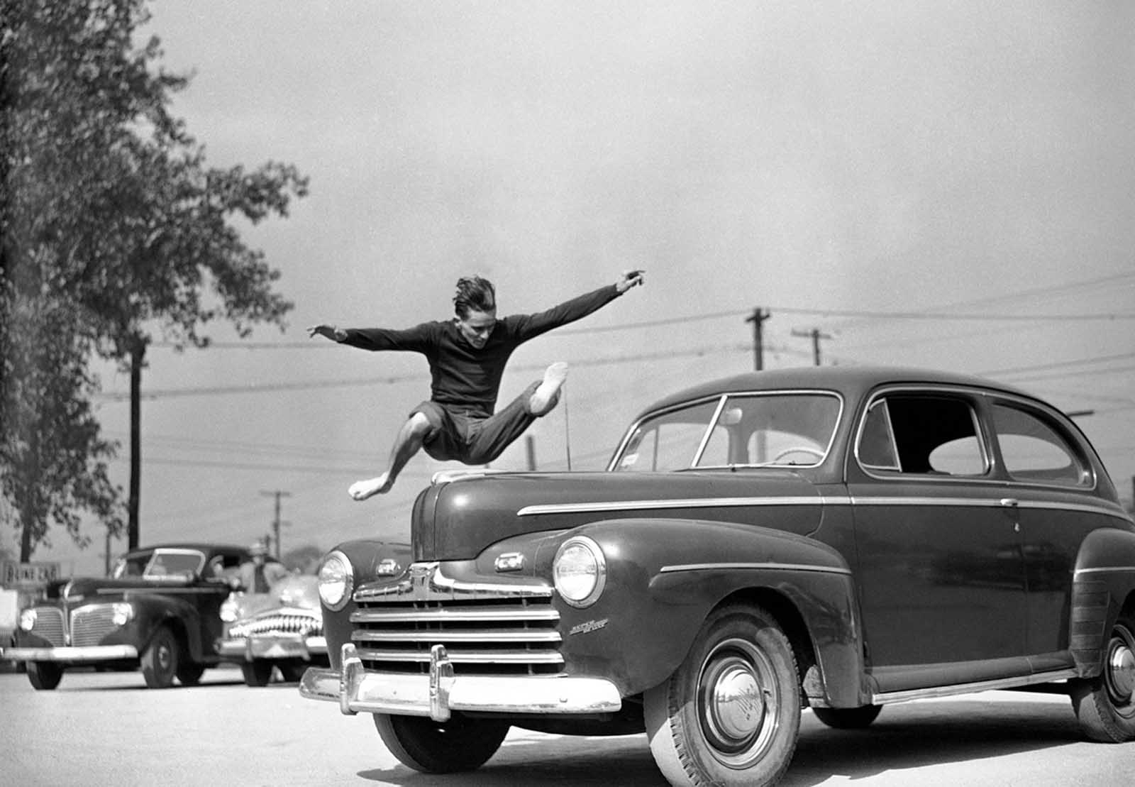 Jockey Freddie “The Fleet” Wirth, a 21-year-old from Louisville, Kentucky, demonstrates how he picked up some extra money in Detroit, when he bet fellow riders he could clear the hood of an automobile, October 29, 1949.