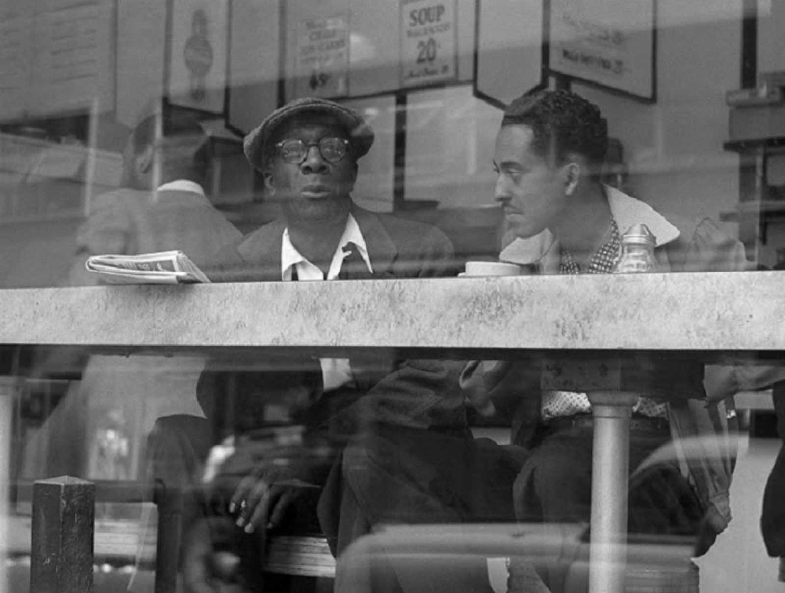 Two men have a conversation in a coffee place near Times Square in April of 1954.