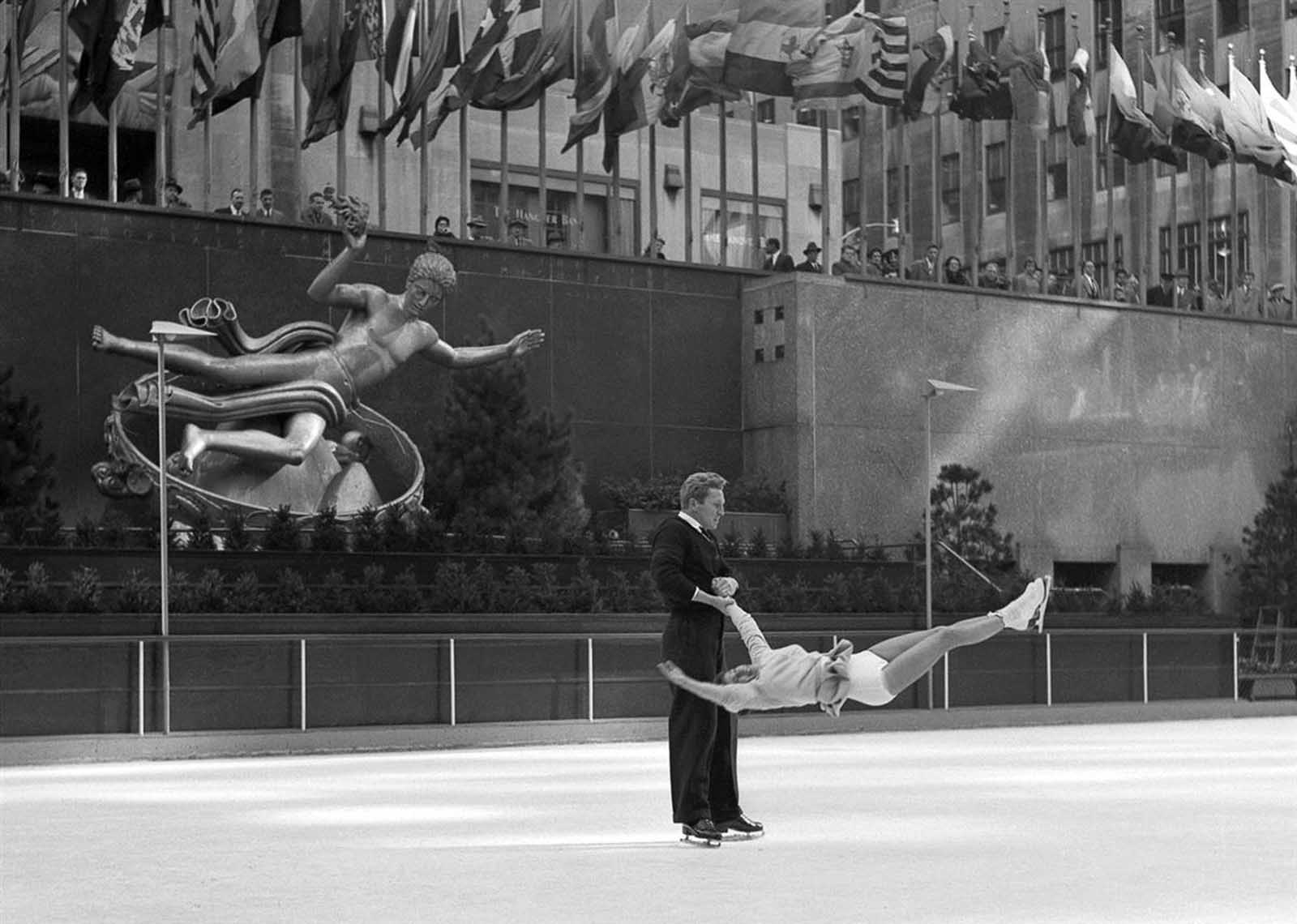 Professional skaters execute turn in mid-air, Rockefeller Center.