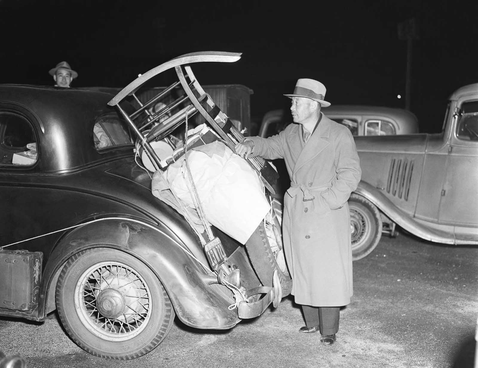 A man in Pasadena packs his car with belongings before heading to the Manzanar War Relocation Camp.