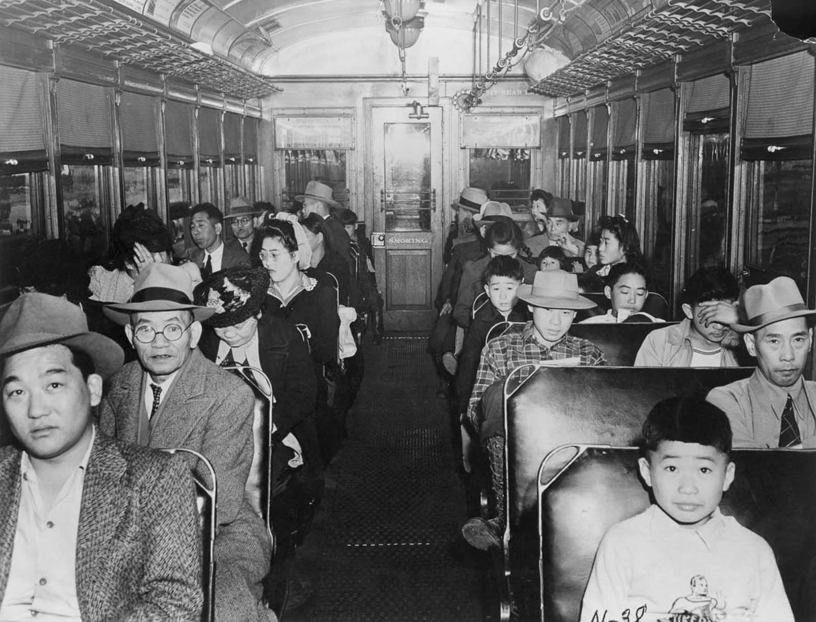 Japanese-Americans ride on a train to an assembly center.