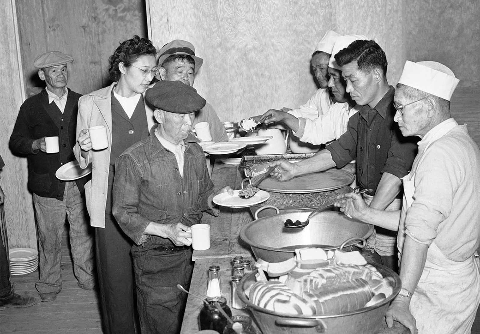 apanese Americans removed from their Los Angeles homes line up at Manzanar Relocation Center, in California, on March 23, 1942, for their first meal after arrival at the camp. Rice, Beans, Prunes, and bread were included in the menu.