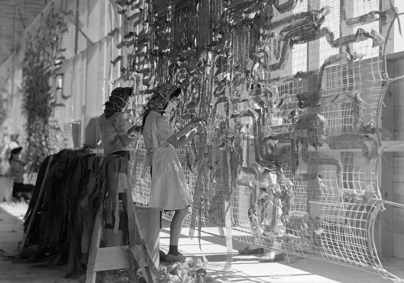 Japanese American evacuees make camouflage nets for the War Department in the Manzanar Relocation Center, in California, on July 1, 1942.