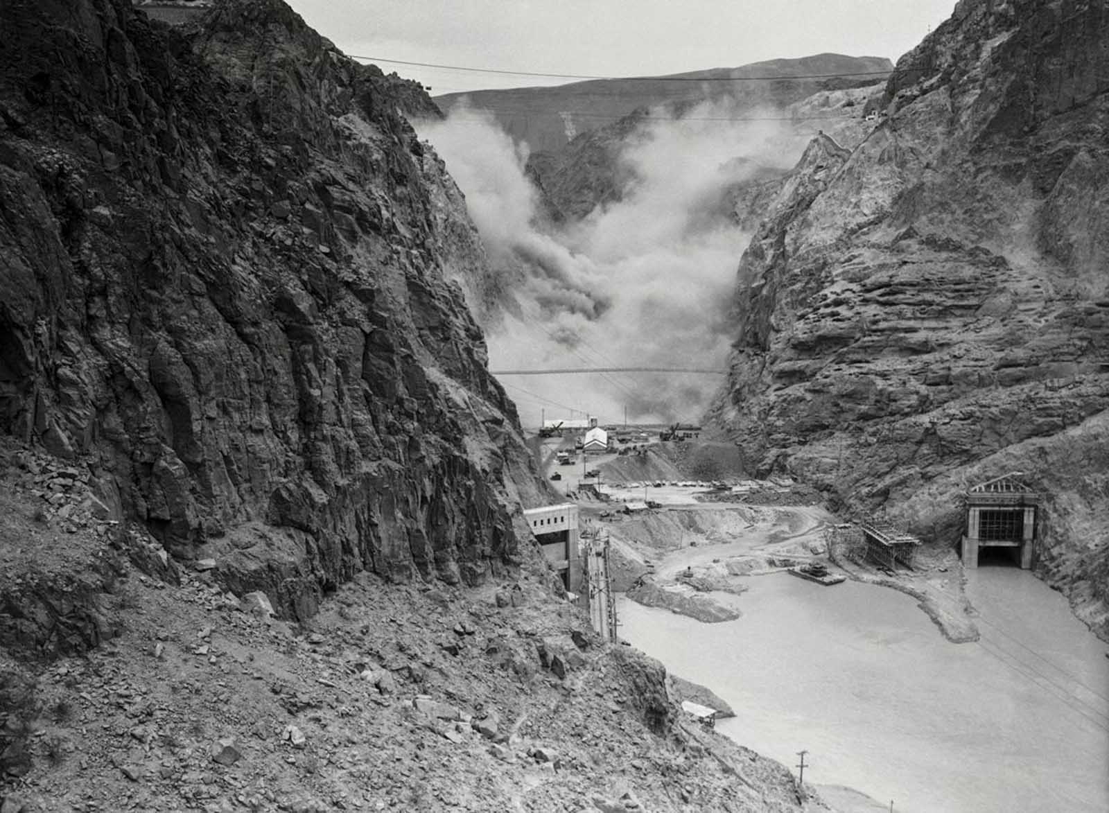 Four tons of dynamite are detonated in the canyon in the early stages of construction. May 12, 1933.