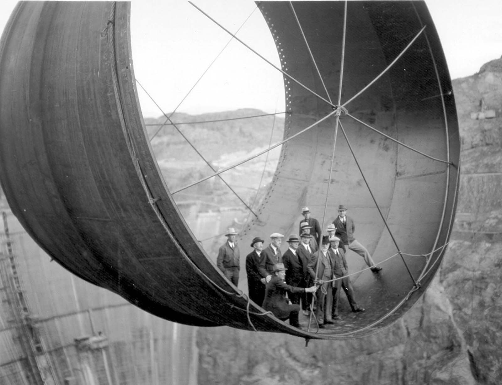 Officials ride in one of the penstock pipes of the soon-to-be-completed Hoover Dam. 1935.
