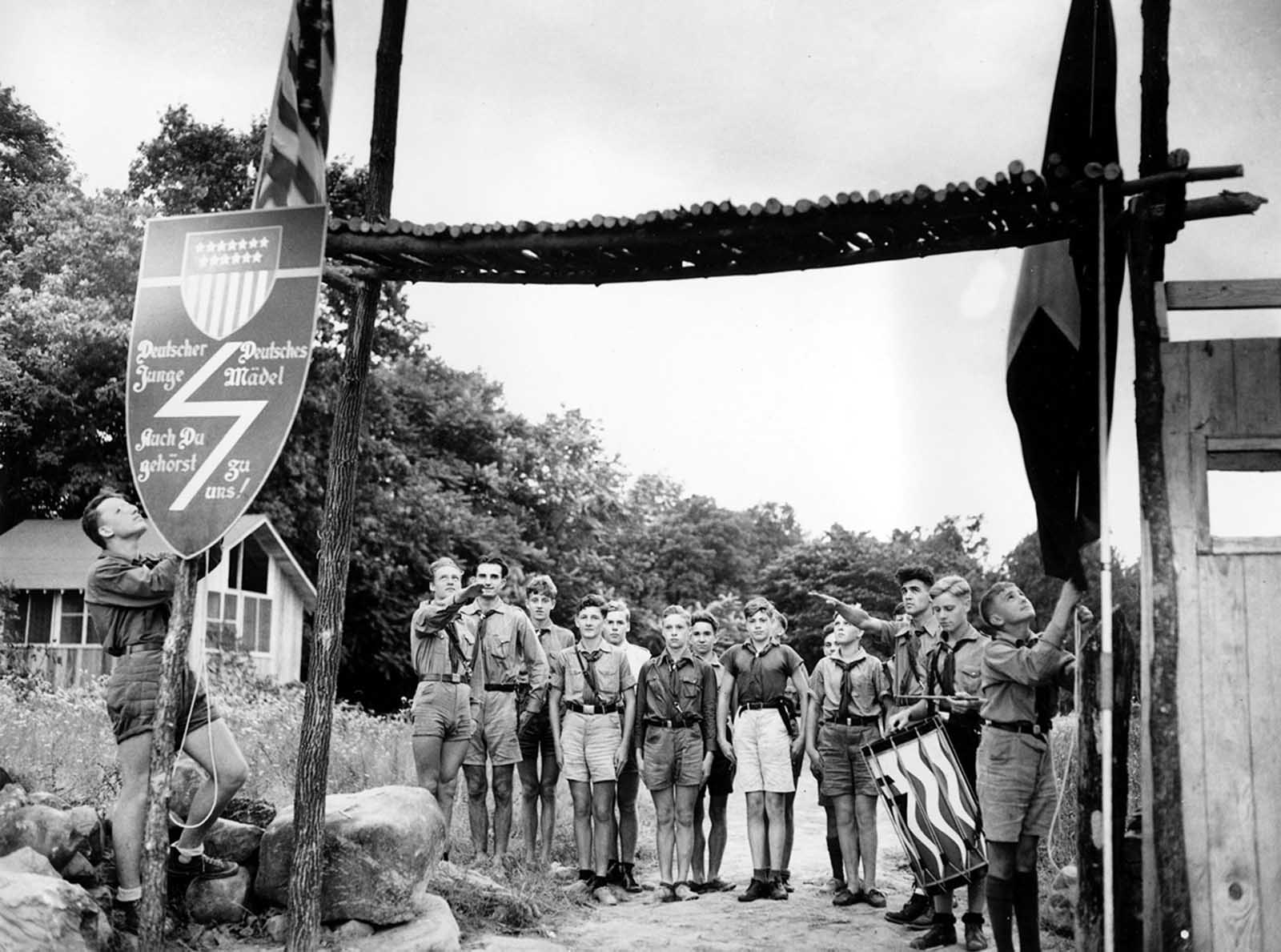 Youths at a German-American Bund camp stand at attention as the American flag and the German-American Youth Movement flag, right, are lowered in a ceremony at sundown in Andover, New Jersey, on July 21, 1937.