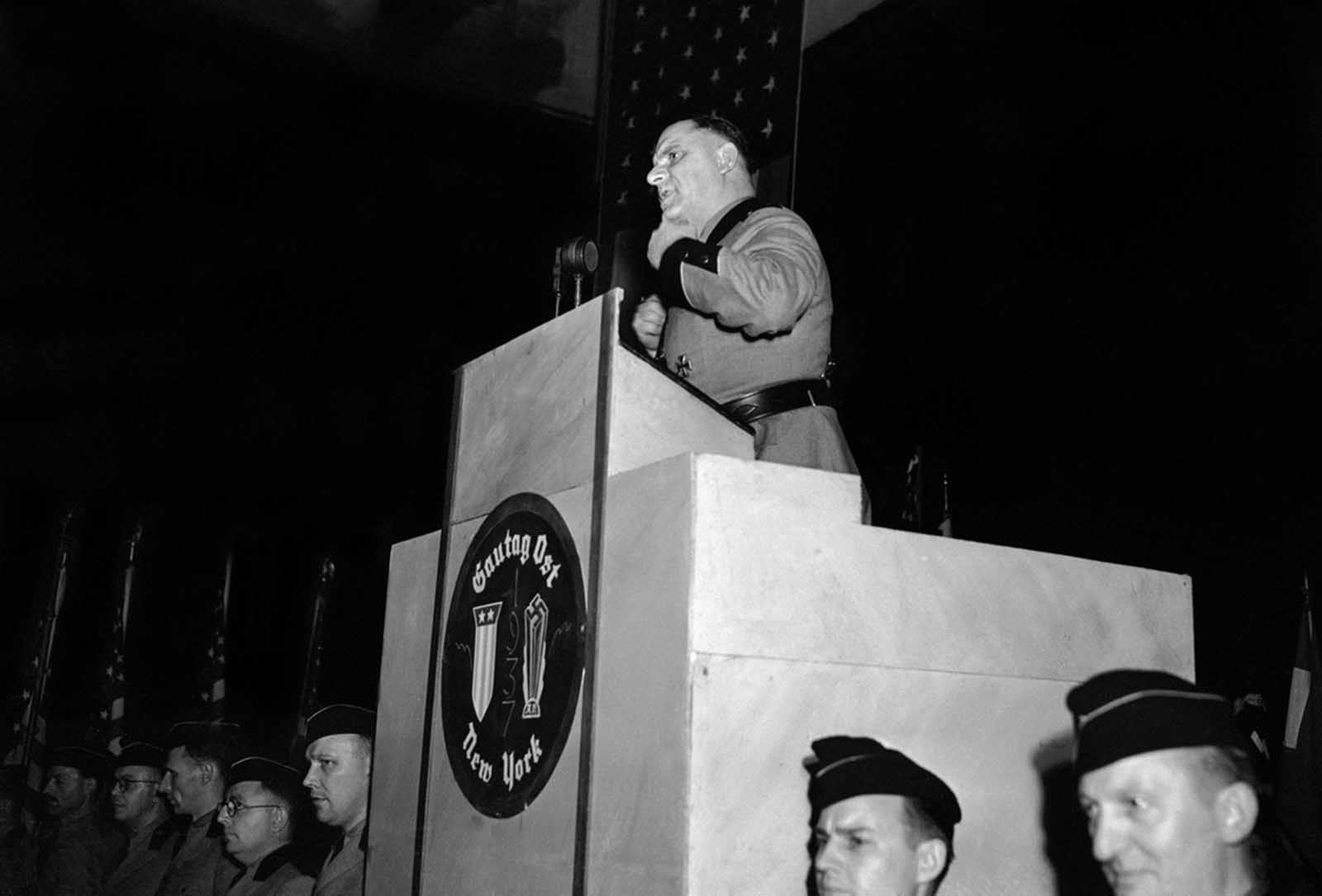 Original Caption: Fritz Kuhn, in the full uniform of a Storm Trooper, national leader of the Bund gestures from the rostrum at Madison Square Garden in New York, on February 20, 1939 while he uttered imprecations against Jews over and over.