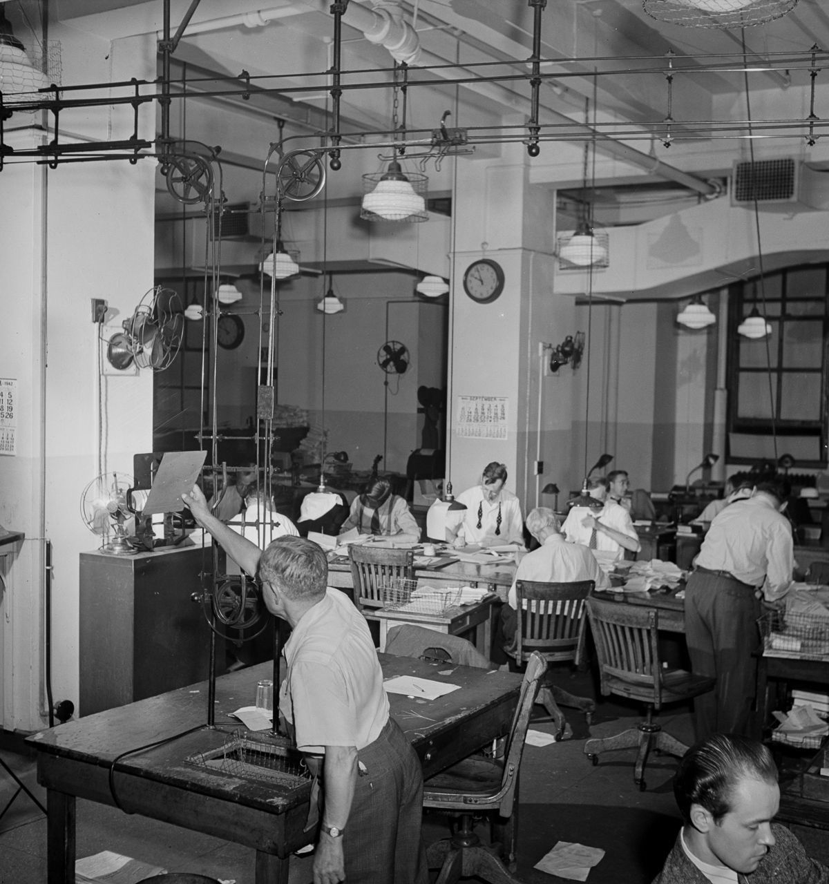 The newsroom. A conveyor belt carries completed copy up to the composing room.