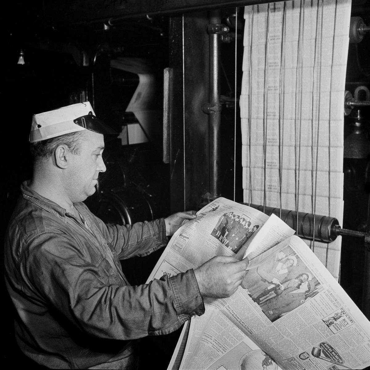 As the first editions come off the press, a pressman inspects for defects.