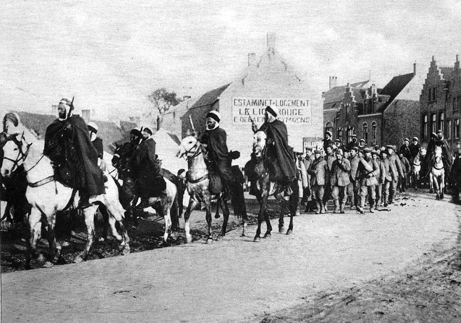 Algerian cavalry attached to the French Army, escorting a group of German prisoners taken in fighting in the west of Belgium.