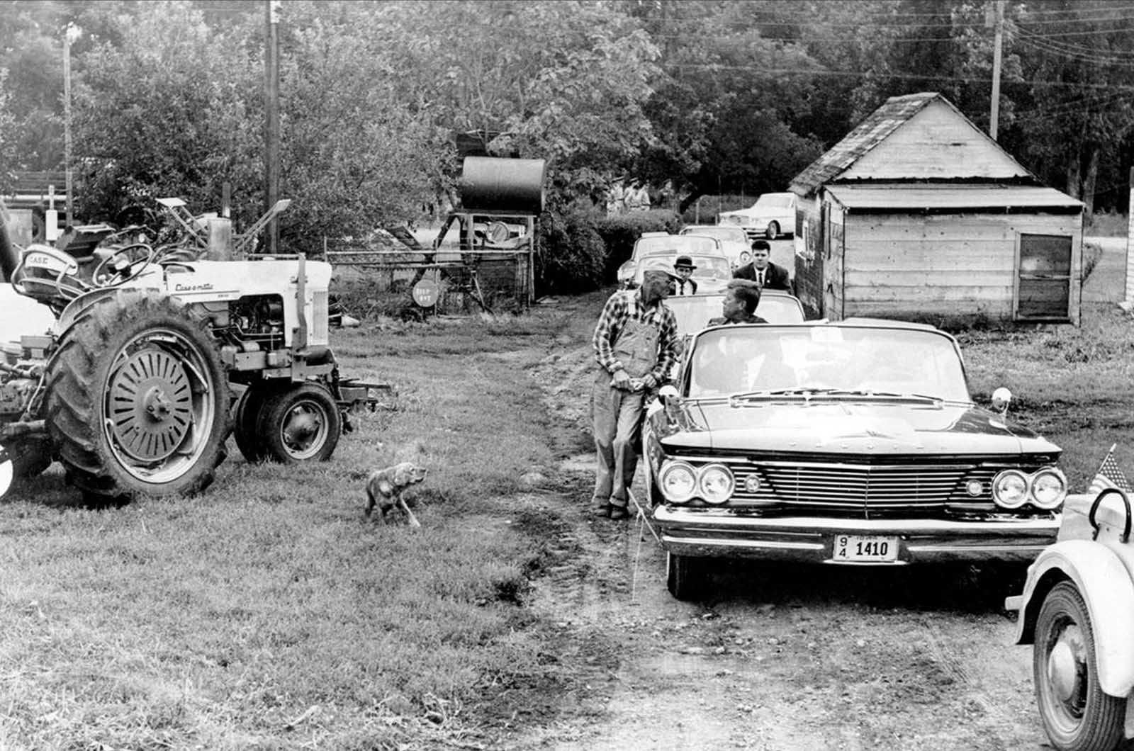 Democratic Presidential nominee Sen. John F. Kennedy, in backseat of Pontiac convertible, talks with farmer James Cox during his campaign visit to the farm in Fort Dodge, Iowa, on September 22, 1960.