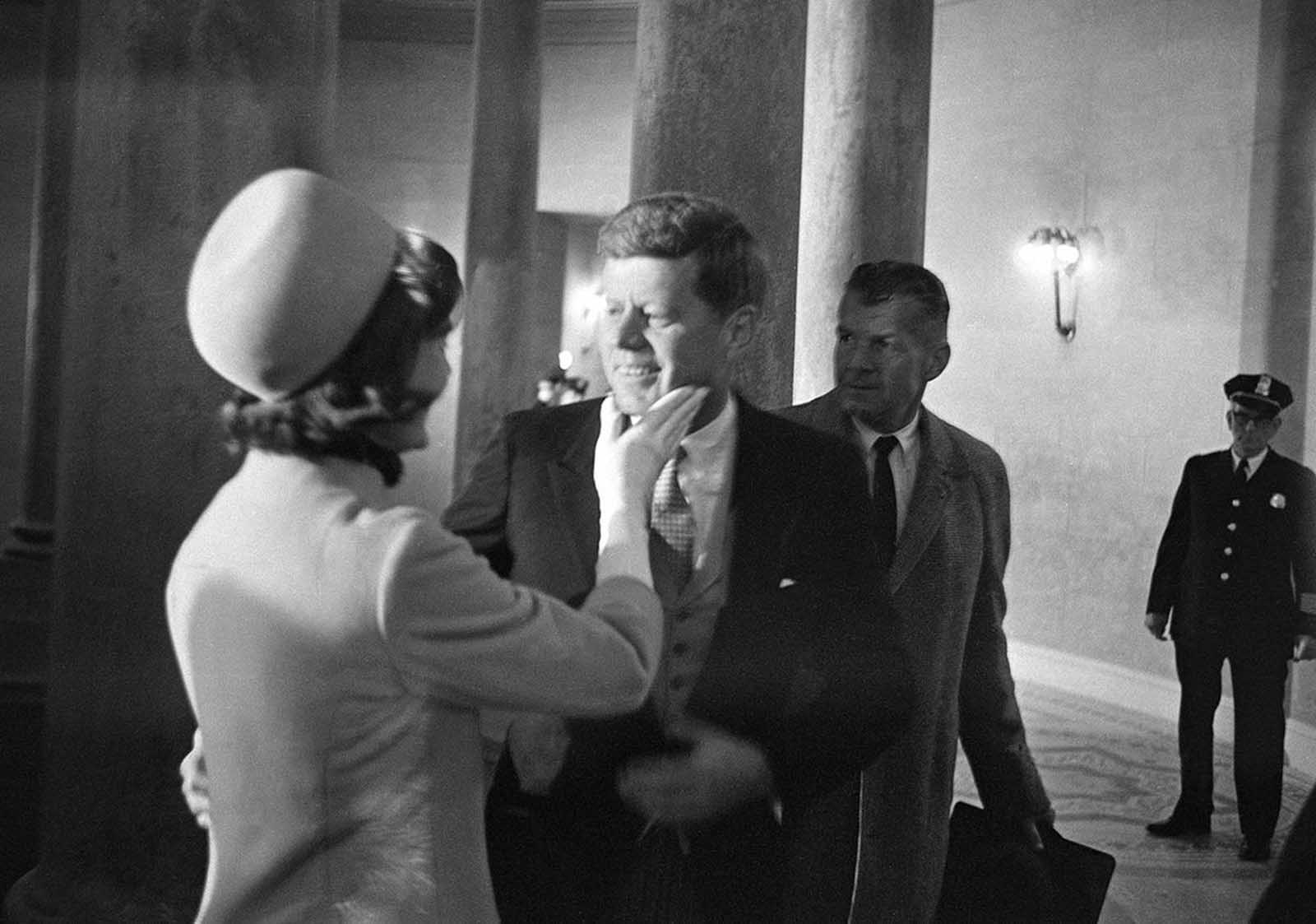 Mrs. Jacqueline Kennedy has a chuck under the chin for her husband moments after he became president, on January 20, 1961. This exclusive picture by AP photographer Henry Burroughs was taken in the rotunda of the Capitol just after President John F. Kennedy left the inaugural stand.