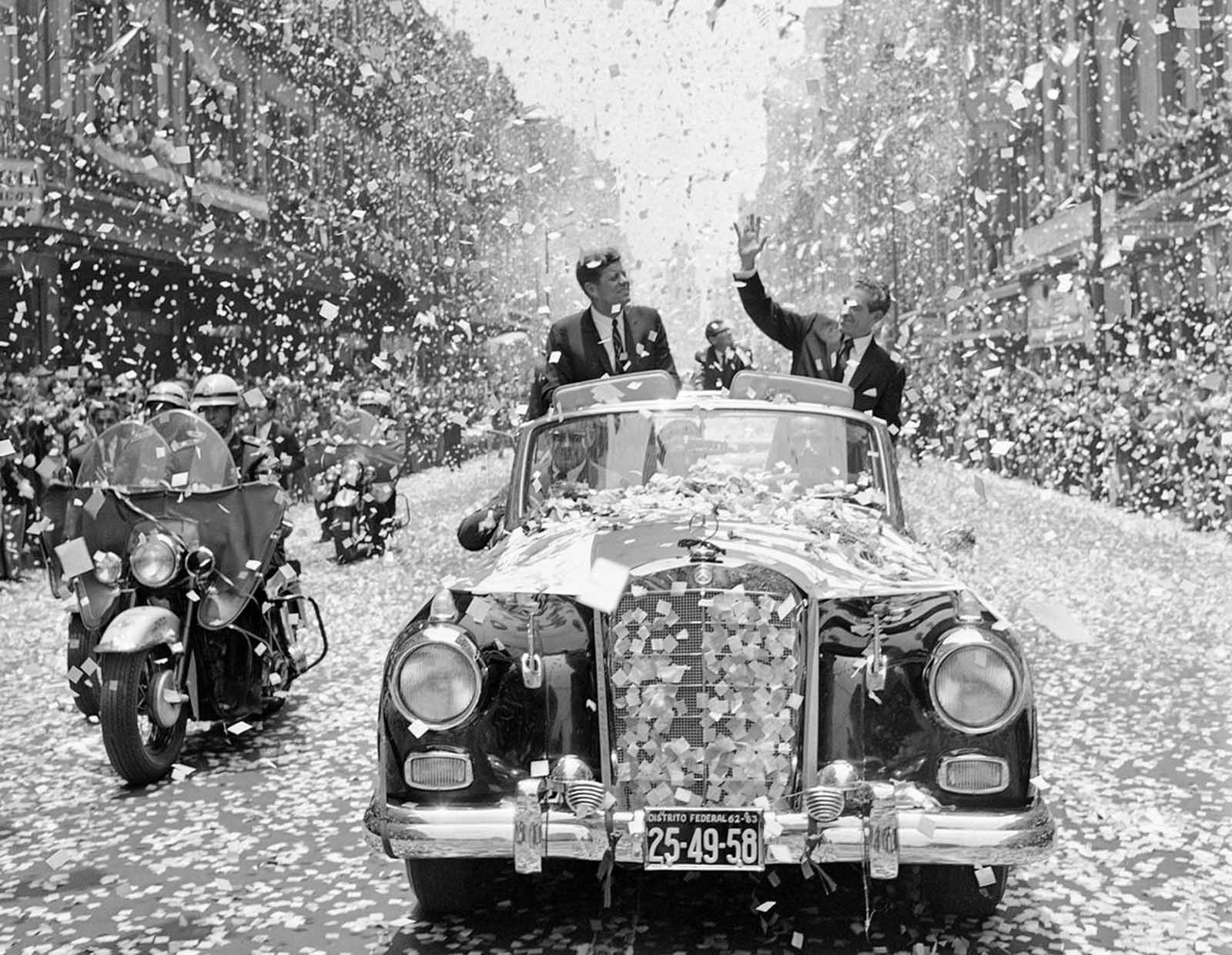 U.S. President John F. Kennedy and Mexican President Adolfo Lopez Mateos are showered with tons of confetti and paper, on June 29, 1962, as they travel down one of Mexico City's boulevards shortly after Kennedy's arrival for a three-day visit.