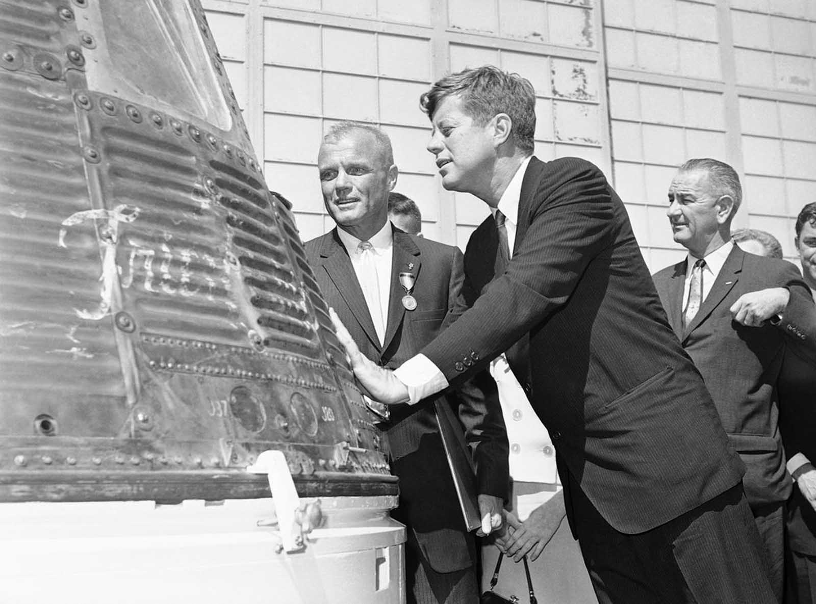 Astronaut John Glenn and President John Kennedy inspect the Friendship 7, the Mercury capsule which Glenn rode in orbit. Kennedy presented the Distinguished Service Medal to Glenn on February 23, 1962 at Cape Canaveral, Florida. 