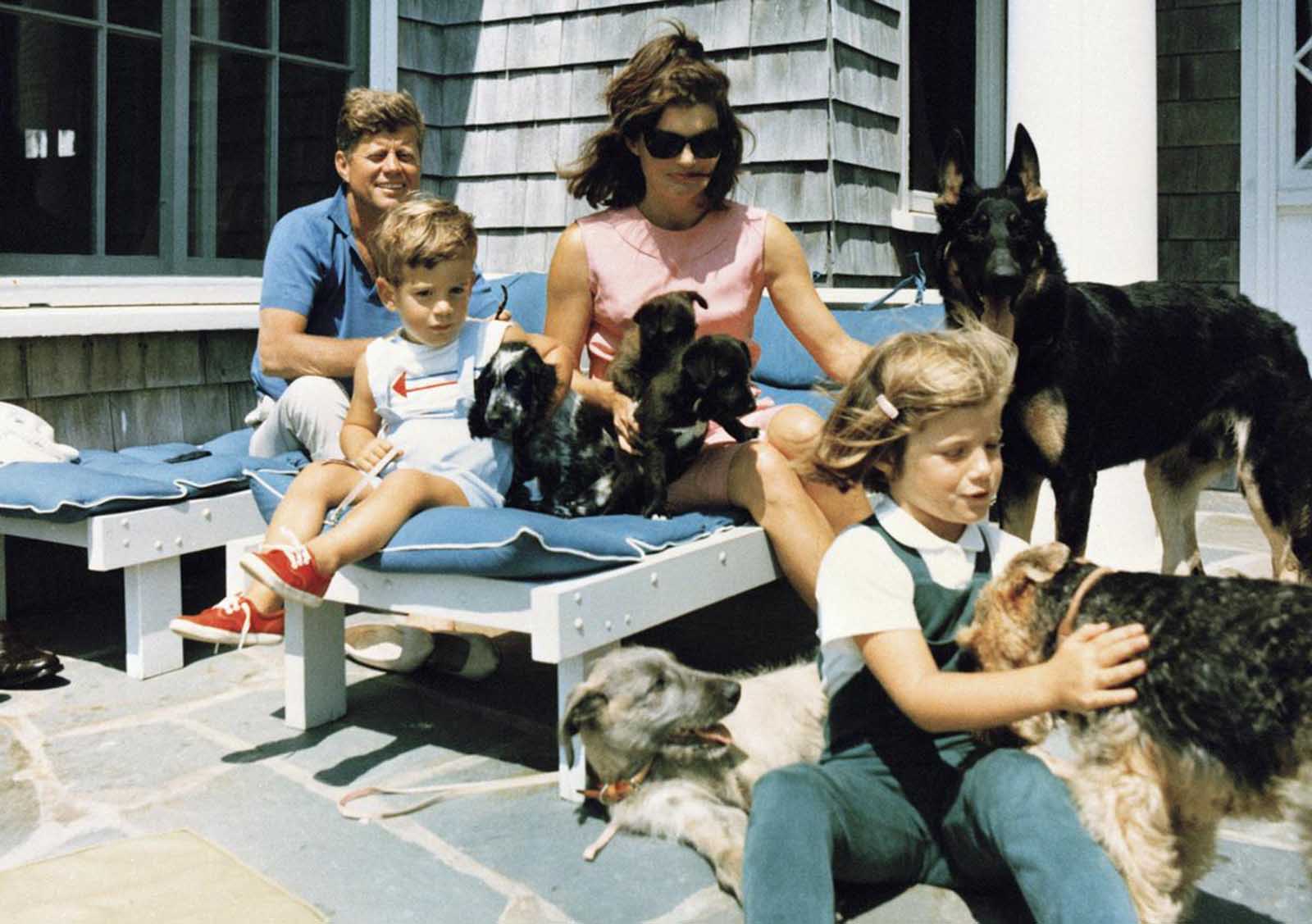 In this photo provided by the White House, President Kennedy, first lady Jacqueline Kennedy and their children, Caroline and John Jr., with the family dogs at their Hyannis Port, Massachusetts, home, on August 14, 1963. 