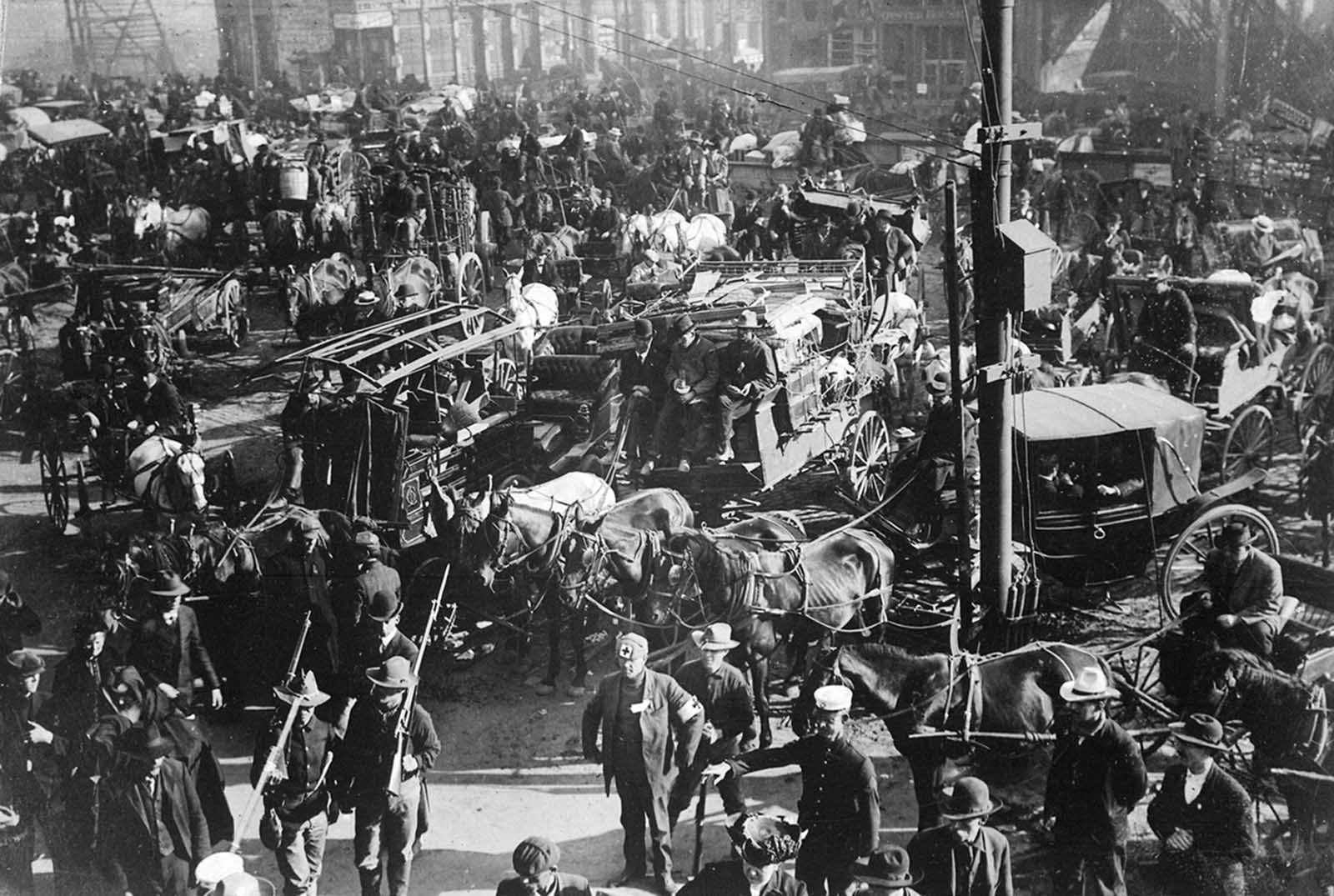Refugees, aid workers, and soldiers clog a San Francisco intersection after the earthquake and fire.