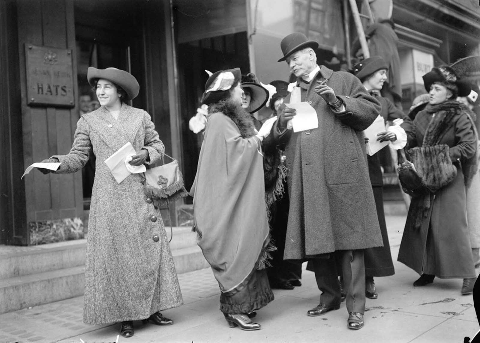 Suffragists hand out flyers advertising the upcoming parade, 1913.