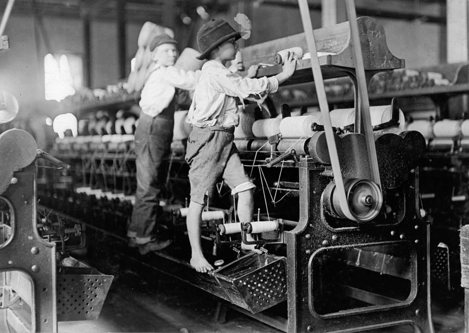 Bibb Mill No. 1 in Macon, Georgia, on January 19, 1909. Some young workers were so small they had to climb up on the spinning frame to mend the broken threads and put back the empty bobbins.