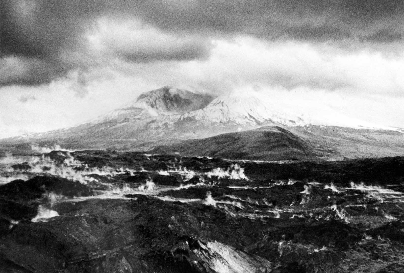The crater left at the summit of Mt. St. Helens, after it lost more than 1,300 feet of elevation to the catastrophic landslide and eruption of May 18, 1980, the surrounding landscape still steaming.