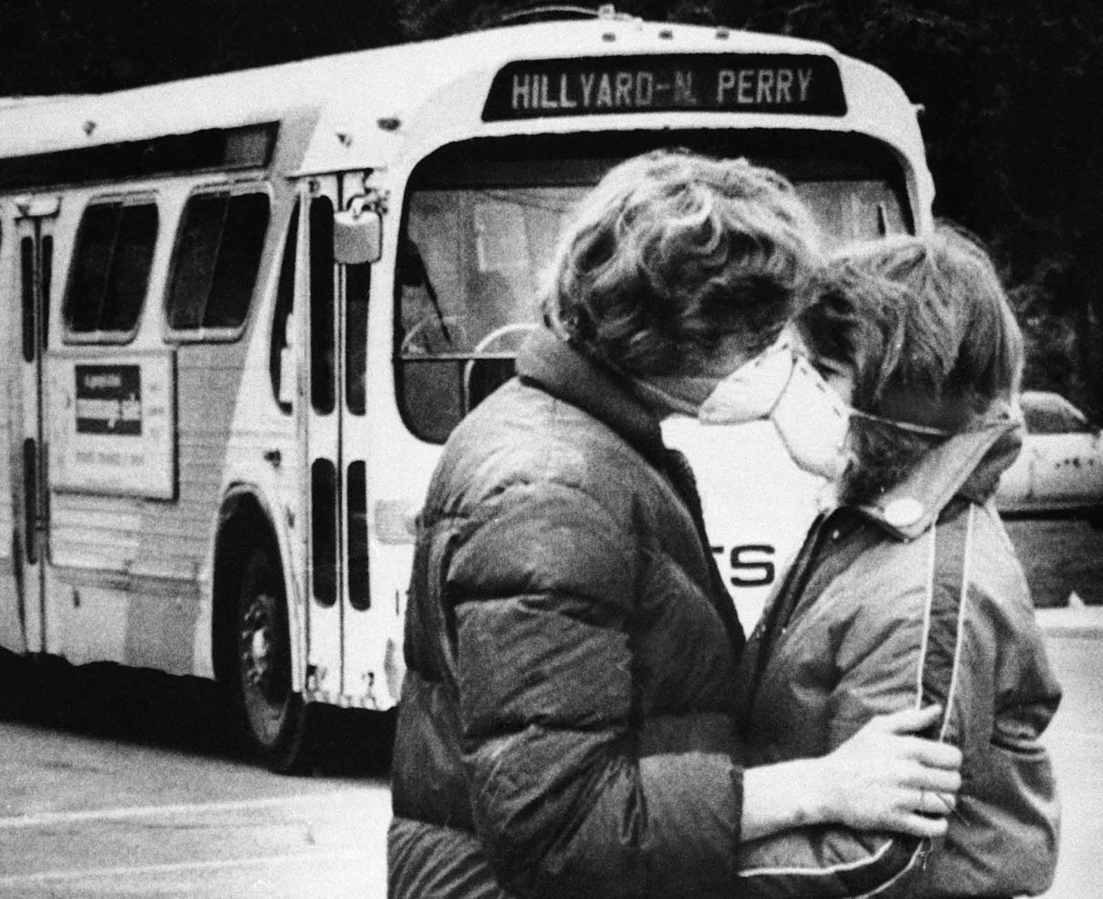 Fifteen-year-old Heidi Havens gives Allen Troup, 16, a kiss as he prepares to board a Spokane City bus, on May 27, 1980. Spokane residents had to wear face masks while outside for days after the eruption because of possible health threats from volcanic ash sprayed over the area by Mount St. Helens on May 18.
