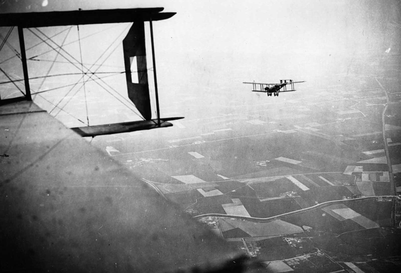 British Handley-Page bombers on a mission, Western Front, during World War I. This photograph, which appears to have been taken from the cabin of a Handley-Page bomber, is attributed to Tom Aitken. It shows another Handley-Page bomber setting out on a bombing mission. The model 0/400 bomber, which was introduced in 1918, could carry 2,000 lbs (907 kilos) of bombs and could be fitted with four Lewis machine-guns.