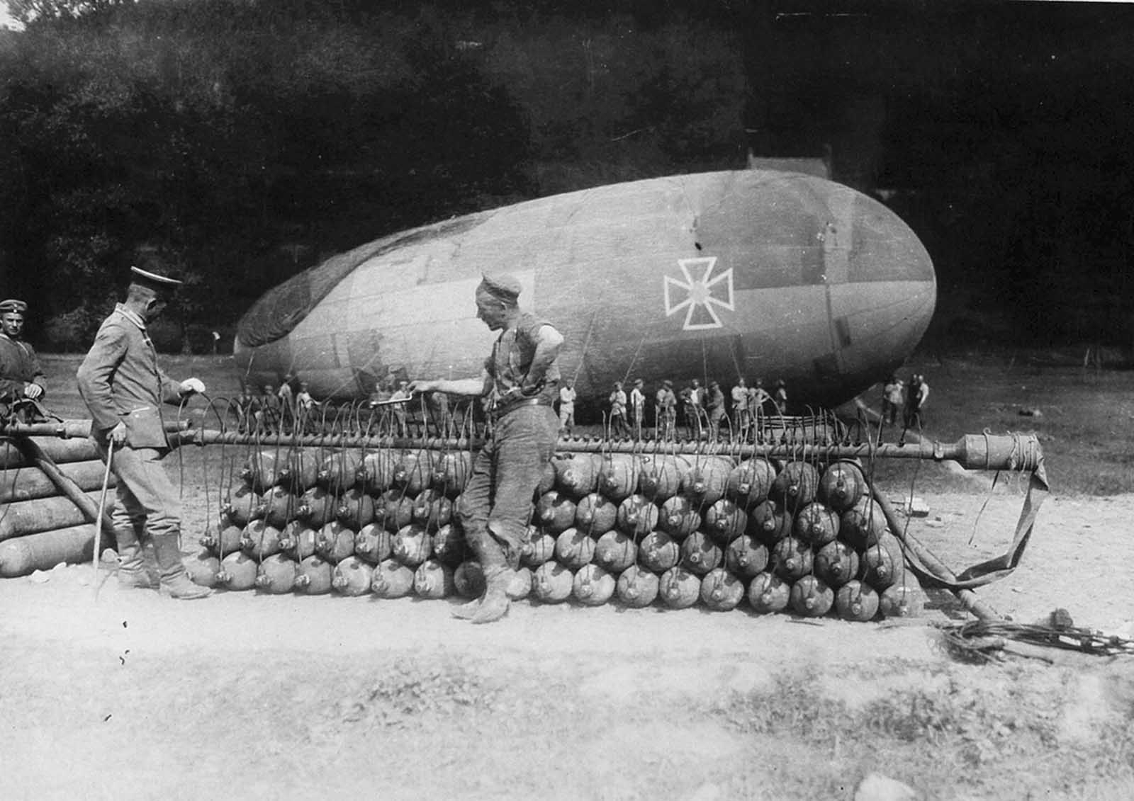 German soldiers attend to a stack of gas canisters attached to a manifold, inflating a captive balloon on the Western front.