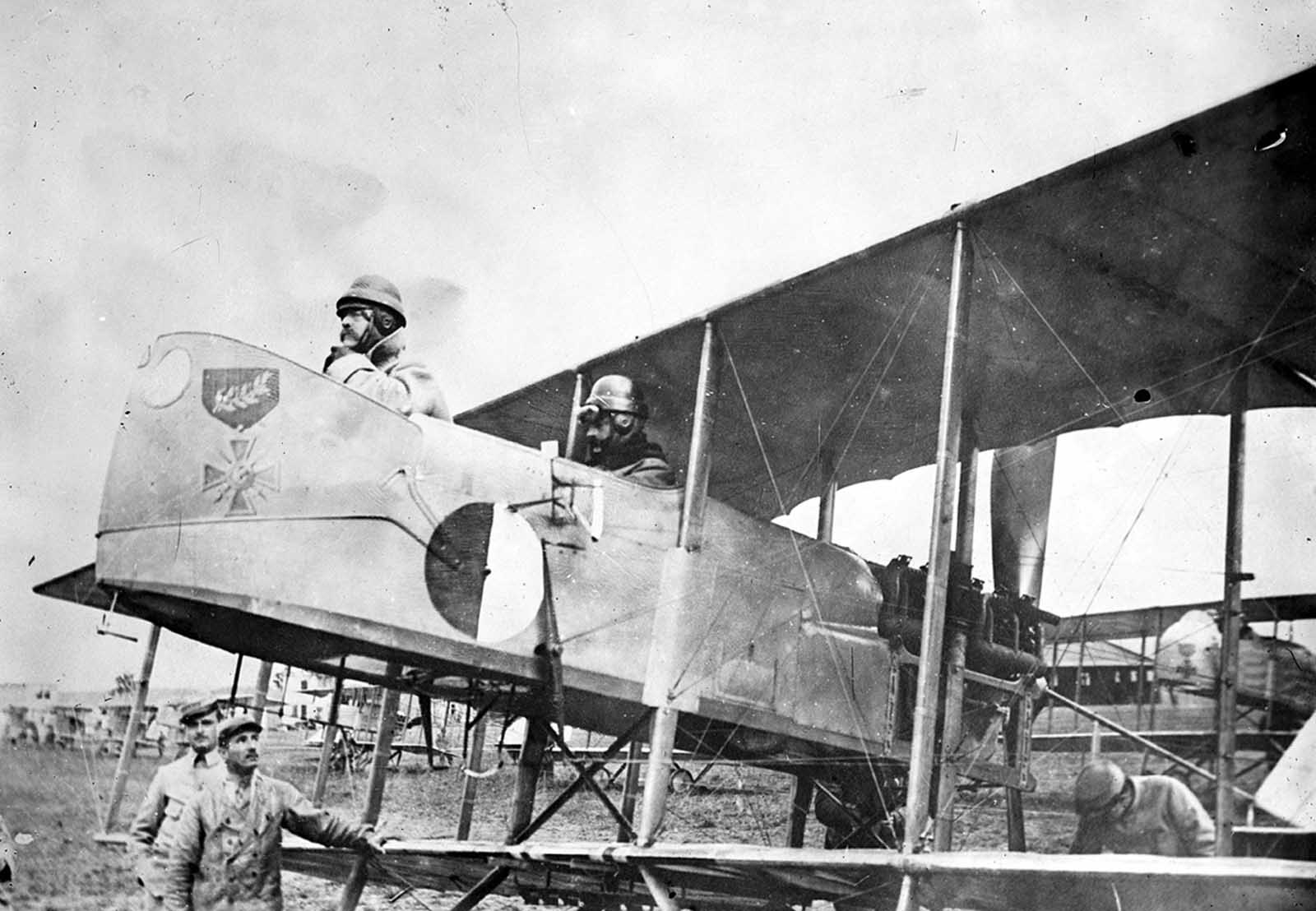 Captain Maurice Happe, rear seat, commander of French squadron MF 29, seated in his Farman MF.11 Shorthorn bomber with a Captain Berthaut. The plane bears the insignia of the first unit, a Croix de Guerre, ca. 1915.