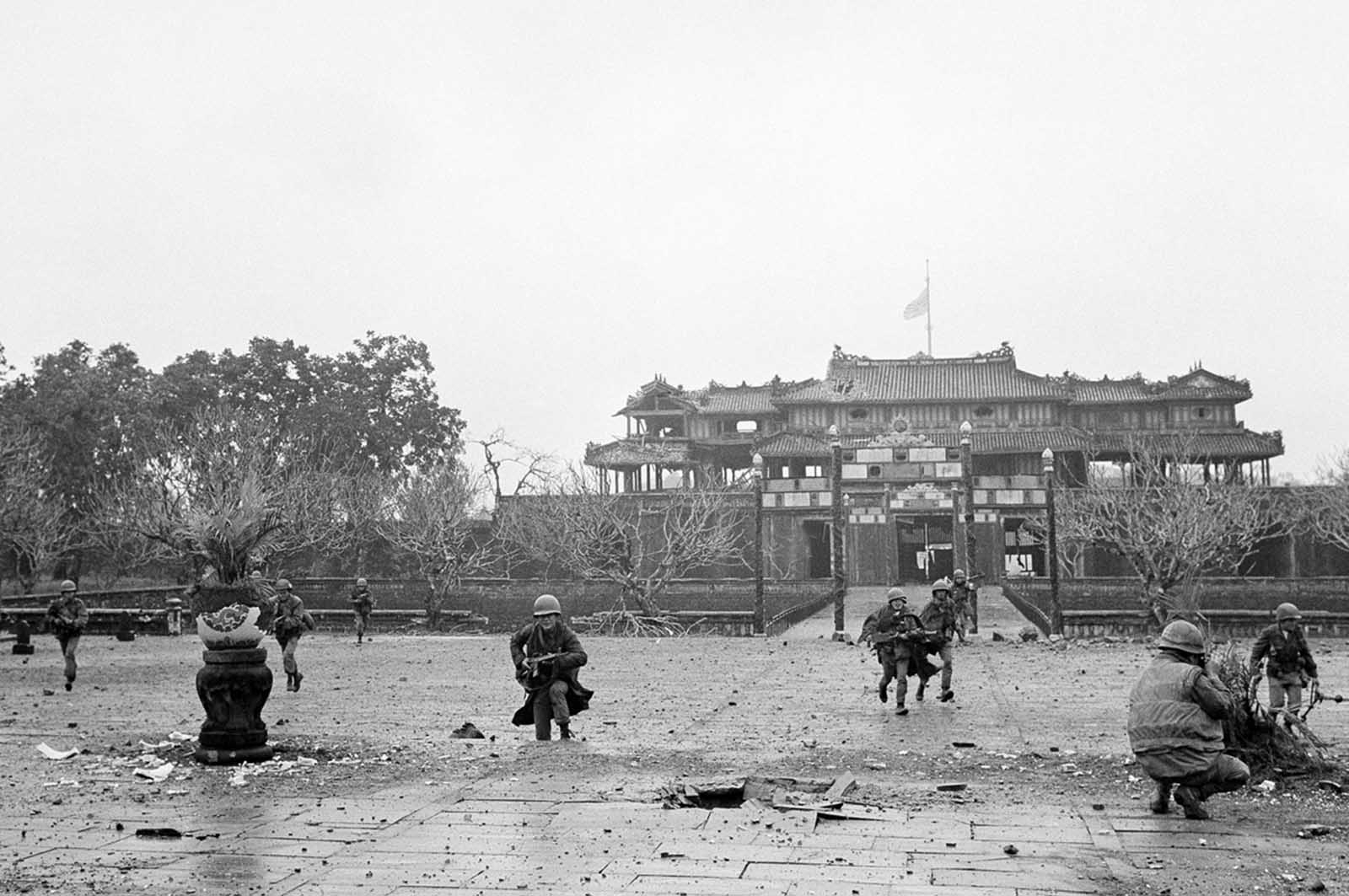 U.S. Marines and Vietnamese troops move through the grounds of the Imperial Palace in the old citadel area of Hue, Vietnam, on February 26, 1968, after seizing it from Communist hands. The heavy damage was the result of the artillery, air, and mortar pounding the area received for 25 days while the Viet Cong/NVA held the area.