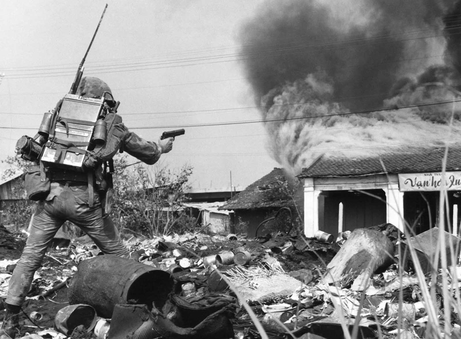 South Vietnamese combat police advance toward a burning building in northeastern Saigon on February 19, 1968, as they battle Viet Cong forces who had occupied several city blocks in the area.