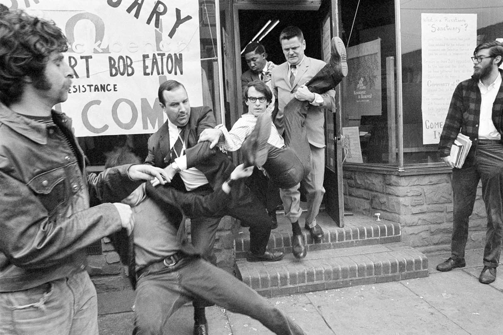 FBI agents carry Vietnam War draft resister Robert Whittington Eaton, 25, from a dwelling in Philadelphia on April 17, 1969, where Eaton had chained himself to 13 young men and women. The agent leading the way pushed one of the group who tried to block path to the sidewalk. At least six young persons were taken away with Easton.